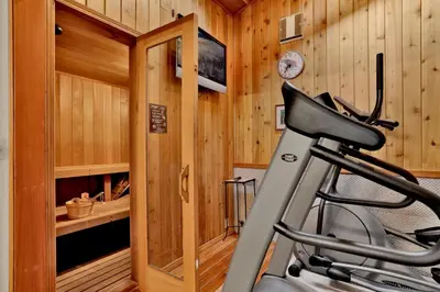 a gym with a treadmill in a room with wooden walls at Big Bear 7th Heaven #714 in Fawnskin