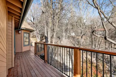 a wooden balcony with a view of the woods at Big Bear 7th Heaven #714 in Fawnskin