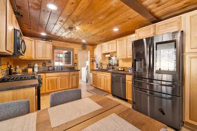 a kitchen with wooden cabinets and a stainless steel refrigerator at Lily's Bear Cabin #2544 in Big Bear Lake