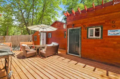 a wooden deck with a table and chairs and an umbrella at Lily's Bear Cabin #2544 in Big Bear Lake