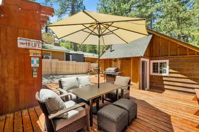 a wooden table with an umbrella on a deck at Lily's Bear Cabin #2544 in Big Bear Lake