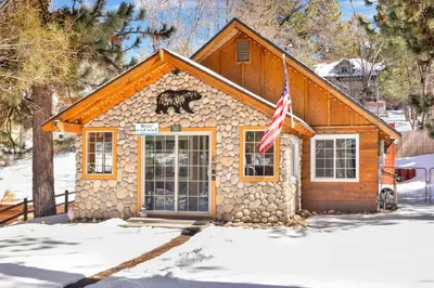 a house with a bear on the front of it in the snow at Lily's Bear Cabin #2544 in Big Bear Lake