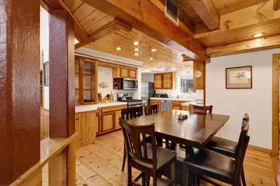 a kitchen and dining room with a wooden table and chairs at Summit Hideaway #445 in Big Bear Lake