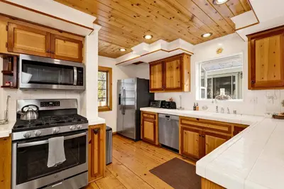 a kitchen with wooden cabinets and a stove at Summit Hideaway #445 in Big Bear Lake