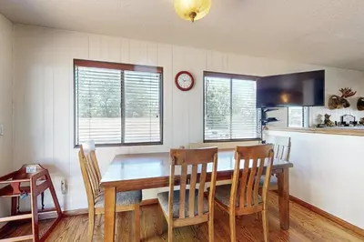 a kitchen with a table and chairs and a clock at Lazy Bear Cabin #554 in Big Bear Lake