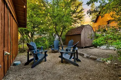 three blue chairs sitting in a yard next to a building at Orchard Family Cabin #2560 in Big Bear Lake