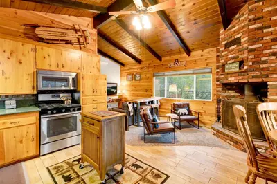 a kitchen and living room with a stove top oven at Orchard Family Cabin #2560 in Big Bear Lake