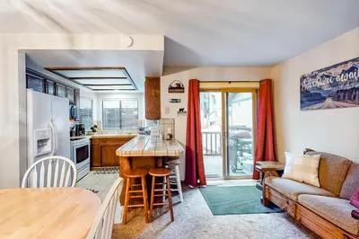 a kitchen and living room with a couch and a table at Rosie's Hideaway #331 in Big Bear Lake