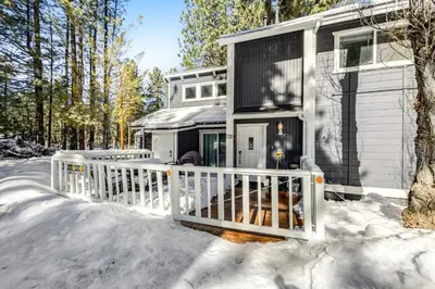 a house with a white fence in the snow at Moose-in' Around in Big Bear Lake
