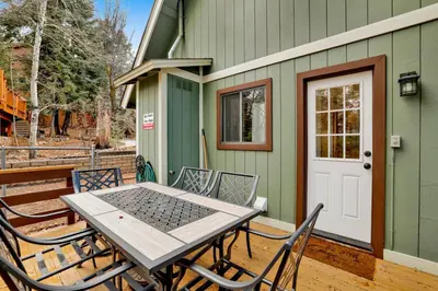 a table and chairs on a deck with a house at Quiet Cabin #564 in Big Bear Lake