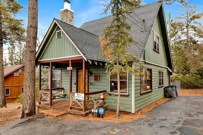 a green house with a sign in front of it at Quiet Cabin #564 in Big Bear Lake
