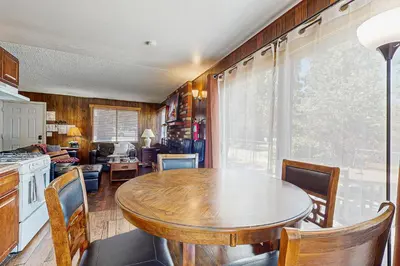 a kitchen with a wooden table and a dining room at Meadow-Front Metcalf Bay Gem #542 in Big Bear Lake