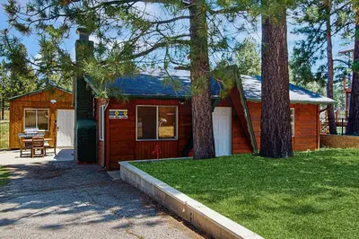 a small cabin with a porch and two trees at Meadow-Front Metcalf Bay Gem #542 in Big Bear Lake
