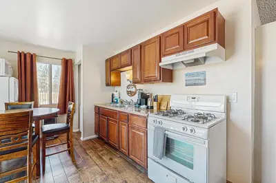 a kitchen with wooden cabinets and a white stove top oven at Meadow-Front Metcalf Bay Gem #542 in Big Bear Lake