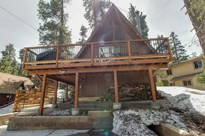 a house with a wrap around deck in the snow at Castle Rock Cabin #2 in Big Bear Lake