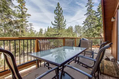 a table and chairs on the balcony of a cabin at Castle Rock Cabin #2 in Big Bear Lake