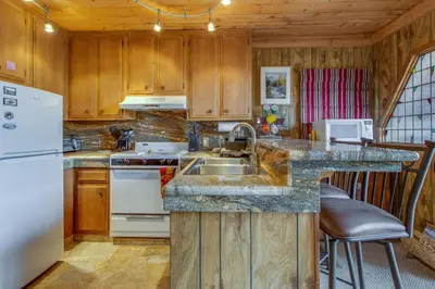 a kitchen with a sink and a white refrigerator at Castle Rock Cabin #2 in Big Bear Lake