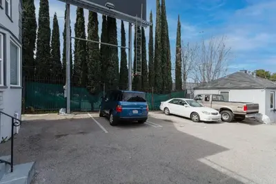 a parking lot with a blue van and a white car at Cozy Studio Studio City Unit 6 in Los Angeles