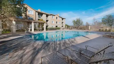 a swimming pool with chairs and a building at Magic Splash Getaway in Santa Clarita