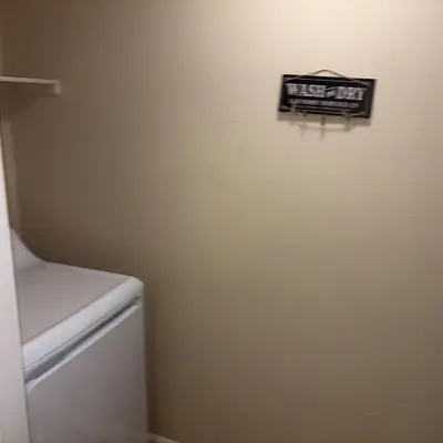 a bathroom with a white refrigerator and a sign on the wall at Magic Splash Getaway in Santa Clarita