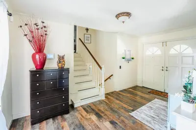 a living room with a staircase and a vase on a dresser at Swinton in North Hills