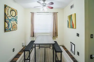 a dining room table with two chairs and a ceiling fan at Swinton in North Hills