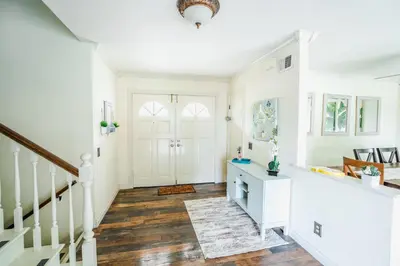 a hallway with white walls and a staircase with wood floors at Swinton in North Hills