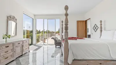 a bedroom with a bed and a dresser with a mirror at Luxe 8000 sqft w 2 Pools Sauna Putting Green Game Room Alta Vista Estate in Los Angeles