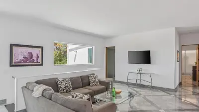 a living room with a couch and a tv at Luxe 8000 sqft w 2 Pools Sauna Putting Green Game Room Alta Vista Estate in Los Angeles