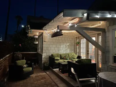 a patio with a couch and a table and lights at Cozy Beach Bungalow- Happynest in Long Beach