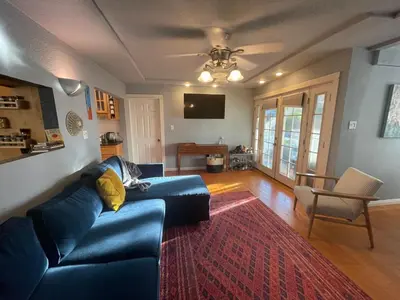 a living room with a blue couch and a red rug at Cozy Beach Bungalow- Happynest in Long Beach