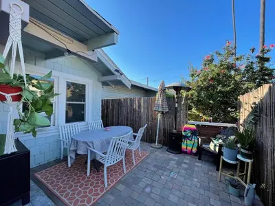 a patio with a table and chairs and a fence at Cozy Beach Bungalow- Happynest in Long Beach