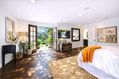 a bedroom with a bed and a desk and a window at Hollywood Hills Spa Retreat Oasis with Tree Top Views, Private Jacuzzi Style Tub, Steam Room, Magical Half Acre Acre Garden and Patio, Free Parking for 2 cars, in LA's most Serene, Central Desirable Area in Los Angeles