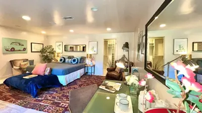 a bedroom with a bed and a living room at Hollywood Hills Spa Retreat Oasis with Tree Top Views, Private Jacuzzi Style Tub, Steam Room, Magical Half Acre Acre Garden and Patio, Free Parking for 2 cars, in LA's most Serene, Central Desirable Area in Los Angeles