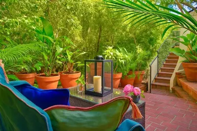 a patio with chairs and a candle on a table at Chic Private Hollywood Hills Guest Suite Oasis with Tree-Top Views, Outdoor Living Room, Only 2 Minutes from Hollywood Boulevard in Los Angeles