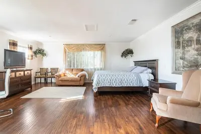 a bedroom with a bed and a couch and a television at King Studio with Self Check-In in Ontario