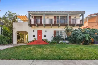 a house with a red door and a balcony at Welcome to The Spanish Hideaway! in Los Angeles