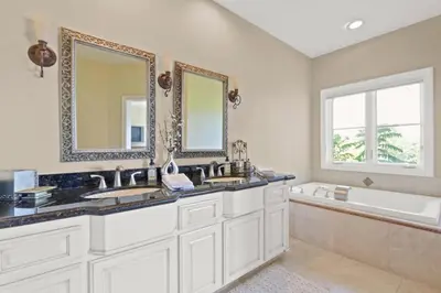 a bathroom with two sinks and a tub and two mirrors at City View Rancho Palos Verdes Home in Rancho Palos Verdes