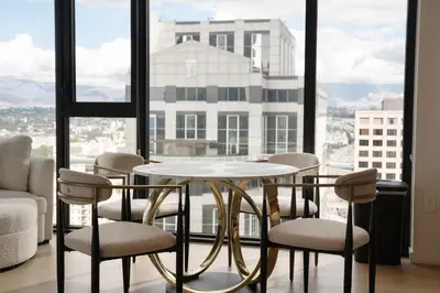 a table and chairs in a room with a large window at Sky High at Beaudry 2 Bed Apt WITH FREE PARKING in Los Angeles