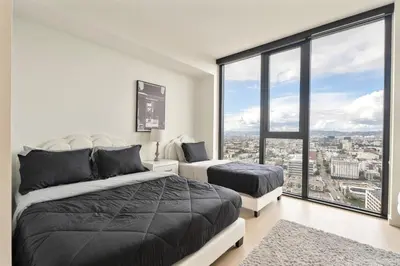 a bedroom with two beds and a large window at Sky High at Beaudry 2 Bed Apt WITH FREE PARKING in Los Angeles