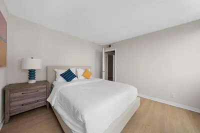 a white bedroom with a bed and a night stand at Breezy & Beautiful - 3BR Marina del Rey Getaway in Los Angeles