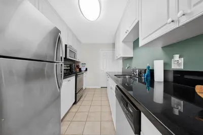 a kitchen with white cabinets and a stainless steel refrigerator at Breezy & Beautiful - 3BR Marina del Rey Getaway in Los Angeles