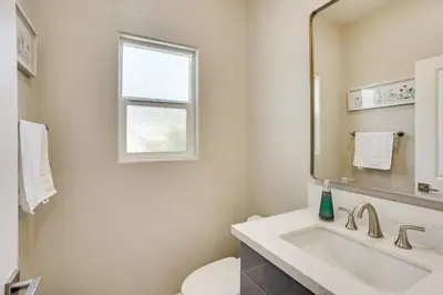 a white bathroom with a sink and a mirror at 2 Mi to Disneyland Home with Furnished Patio! in Anaheim