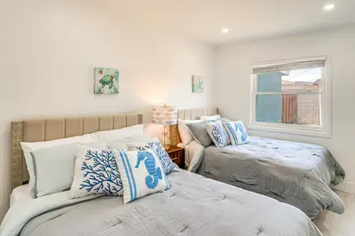 a bedroom with two beds and a window at 7 Mi Huntington Beach Family Home with Patio! in Midway City