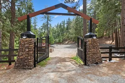 an entrance to a gate in the woods at Arrowhead Ranch Retreat and Conference Center in Lake Arrowhead