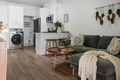 a living room with a green couch and a table at All New Apt Mins Beach, Downtown & Convention Ctr LB ADU in Long Beach