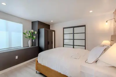 a bedroom with a large bed and a window at Hillside Guest House with Sunset View in Los Angeles