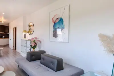 a living room with a couch and a picture on the wall at Hillside Guest House with Sunset View in Los Angeles