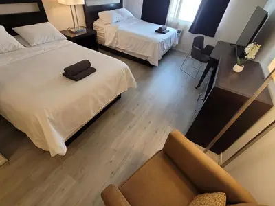 a hotel room with two beds and a chair at Beverly Hills Nest in Los Angeles