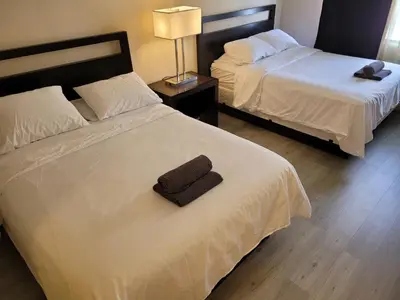 two beds in a hotel room with a towel on the bed at Beverly Hills Nest in Los Angeles
